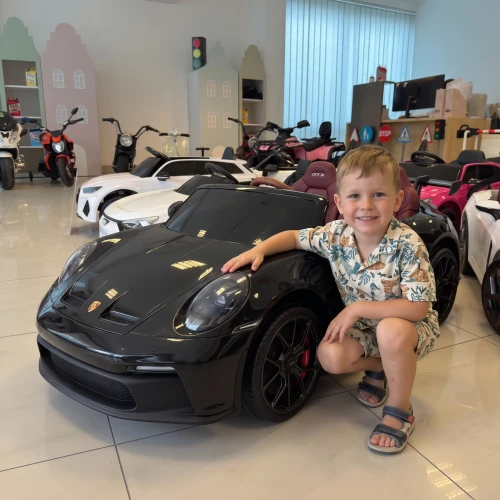 porshe 911 gt3 z dzieckiem - dziecko odbiera z salonu merikids swoje pierwsze autko na akumulator.webp