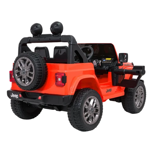 Pomarańczowy Jeep Wrangler na akumulator w ujęciu tylno-bocznym – koło zapasowe, aluminiowe felgi i terenowe opony w elektrycznym pojeździe dla dzieci.webp