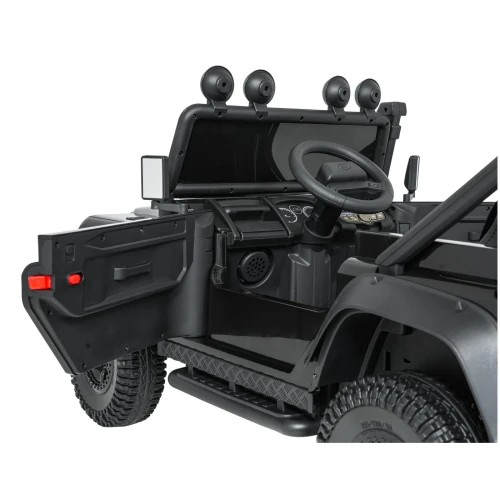 Otwarte drzwi, kierownica i deska rozdzielcza – wnętrze czarnego Land Rovera Defender 110 SVX Concept na akumulator dla dzieci.webp