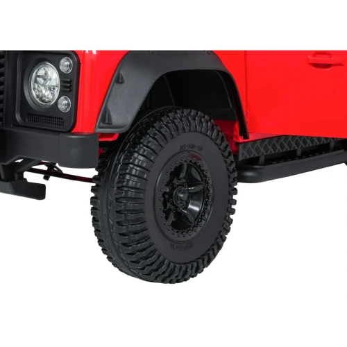 Koło z terenową oponą i czarną felgą – zbliżenie czerwonego Land Rovera Defender 110 SVX Concept na akumulator dla dzieci.webp