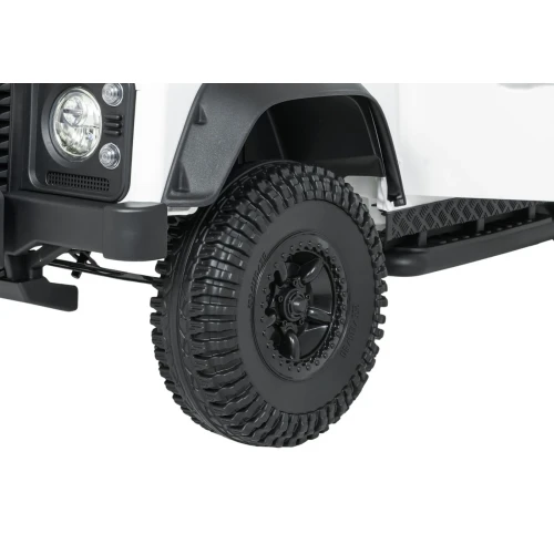 Koło z terenową oponą i czarną felgą – zbliżenie białego Land Rovera Defender 110 SVX Concept na akumulator dla dzieci.webp