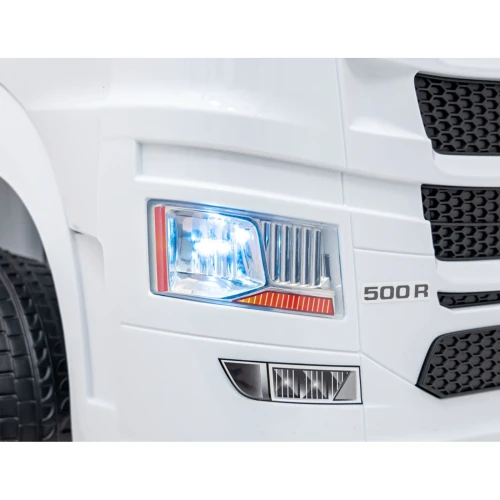 Przedni reflektor LED i emblemat 500 R – zbliżenie białej Scanii R Serie na akumulator dla dzieci.webp
