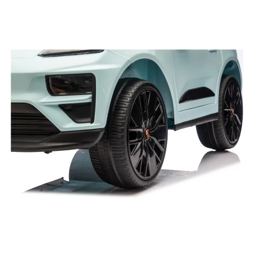 Przednie koło z czarną felgą i emblematem Porsche – zbliżenie miętowego Porsche Macan Turbo na akumulator dla dzieci.webp