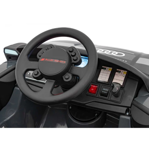 Kierownica Audi Sport i ekrany na desce rozdzielczej – kokpit szarego Audi RSQ e-tron na akumulator dla dzieci.webp