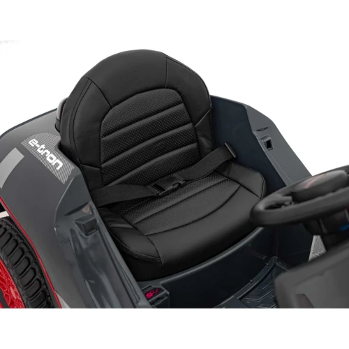 Skórzany fotel z pasem bezpieczeństwa i napis e-tron – wnętrze szarego Audi RSQ e-tron, auta elektrycznego na akumulator dla dzieci.webp