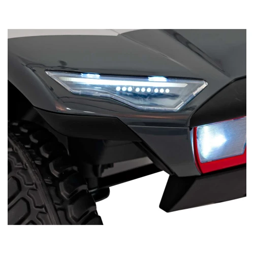 Przedni reflektor LED i świecący halogen w czerwonym zderzaku – zbliżenie szarego Audi RSQ e-tron, auta elektrycznego na akumulator dla dzieci.webp