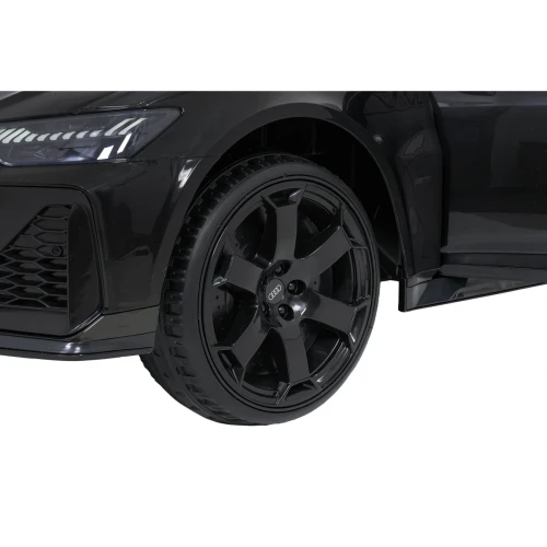 Koło z czarną felgą z logo Audi i bieżnikiem opony – zbliżenie czarnego Audi RS6 Avant GT, auta elektrycznego na akumulator dla dzieci.webp