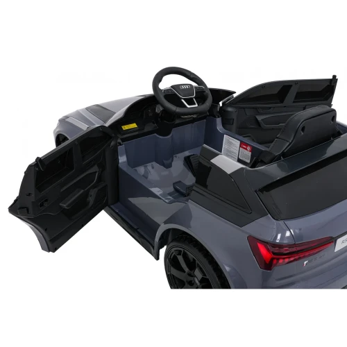Otwarte drzwi, pedał gazu i fotel z pasami bezpieczeństwa – przestronna kabina szarego Audi RS6 Avant GT na akumulator dla dzieci.webp