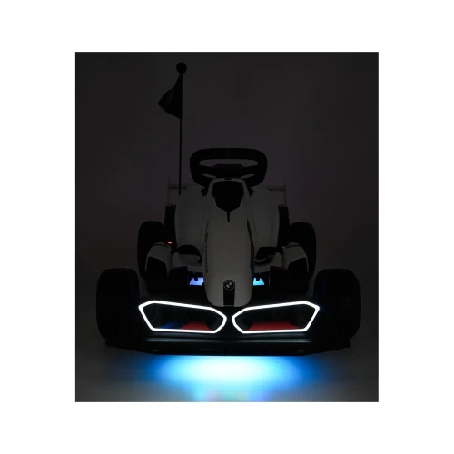 Widok z przodu po ciemku z włączonymi światłami LED – biały gokart BMW z funkcją driftu na akumulator dla dzieci.webp
