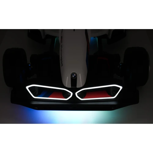 Zbliżenie świecącego grilla LED i emblematu BMW nocą – oświetlenie białego gokarta BMW Drift na akumulator dla dzieci.webp