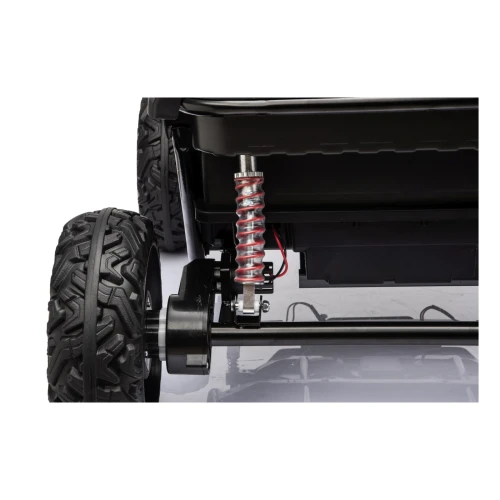 Tylny amortyzator sprężynowy i silnik przy kole – zbliżenie zawieszenia czerwonego buggy Sport Outland 4x4 na akumulator dla dzieci.webp